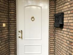 Weiße Haustür mit goldenem Türklopfer in Neuss